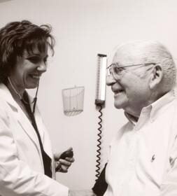 A patient having his blood pressure taken by a...