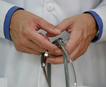 doctor's hands holding stethoscope