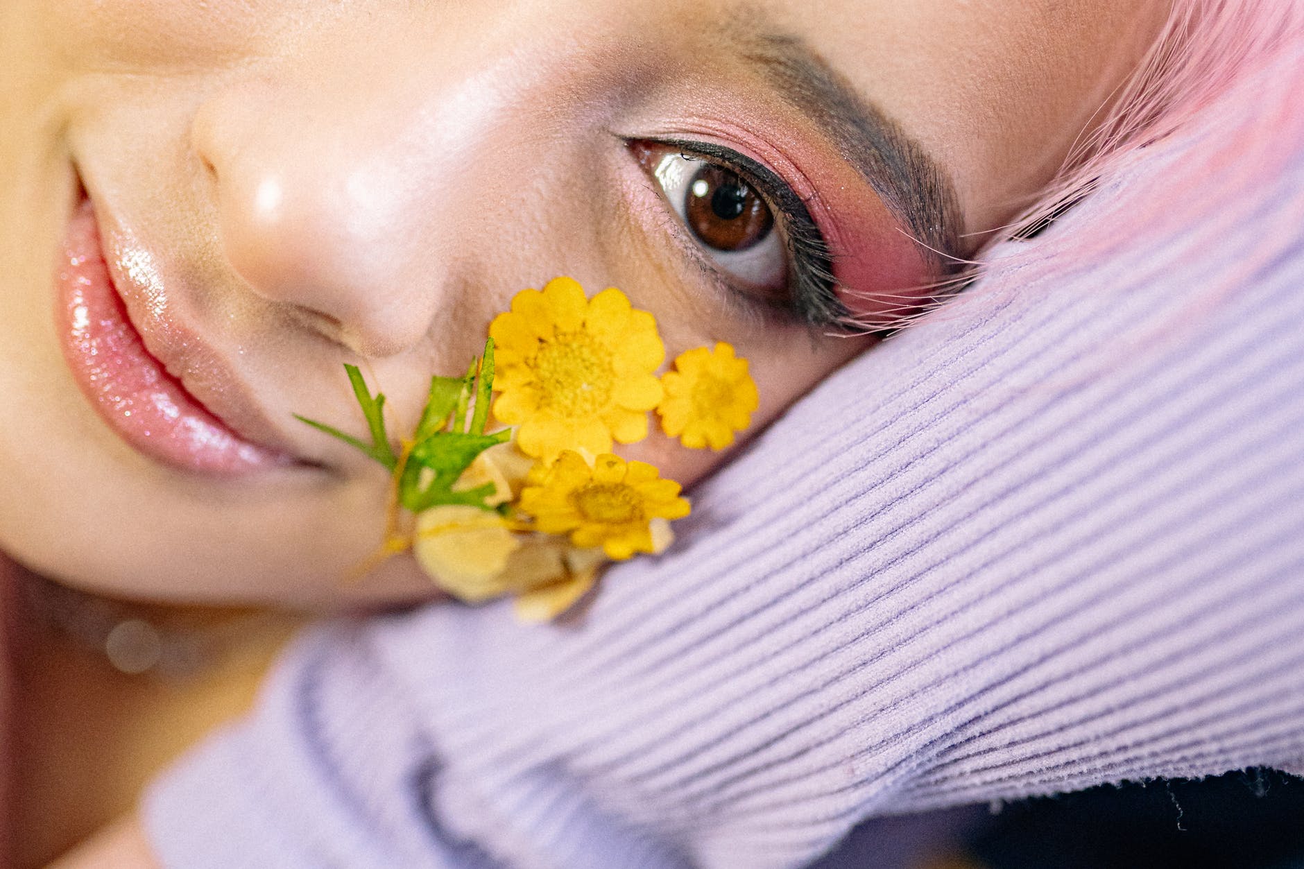 close up shot of woman with yellow flowers on her cheek