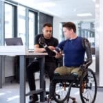 engineer fitting prosthetic arm