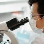man looking through a microscope