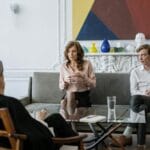 woman in pink long sleeve shirt sitting on gray couch
