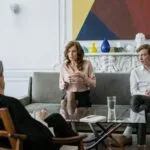 woman in pink long sleeve shirt sitting on gray couch