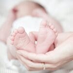 close up of hands holding baby feet