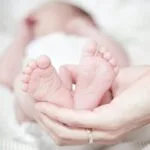close up of hands holding baby feet