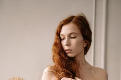 photo of a woman with red hair holding a brown brush